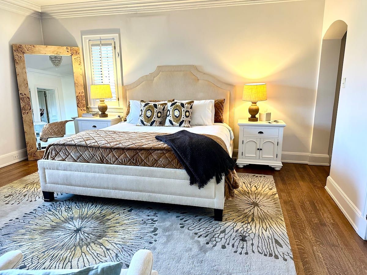 Gold Room — king bed with bronze quilted coverlet and antique floor mirror