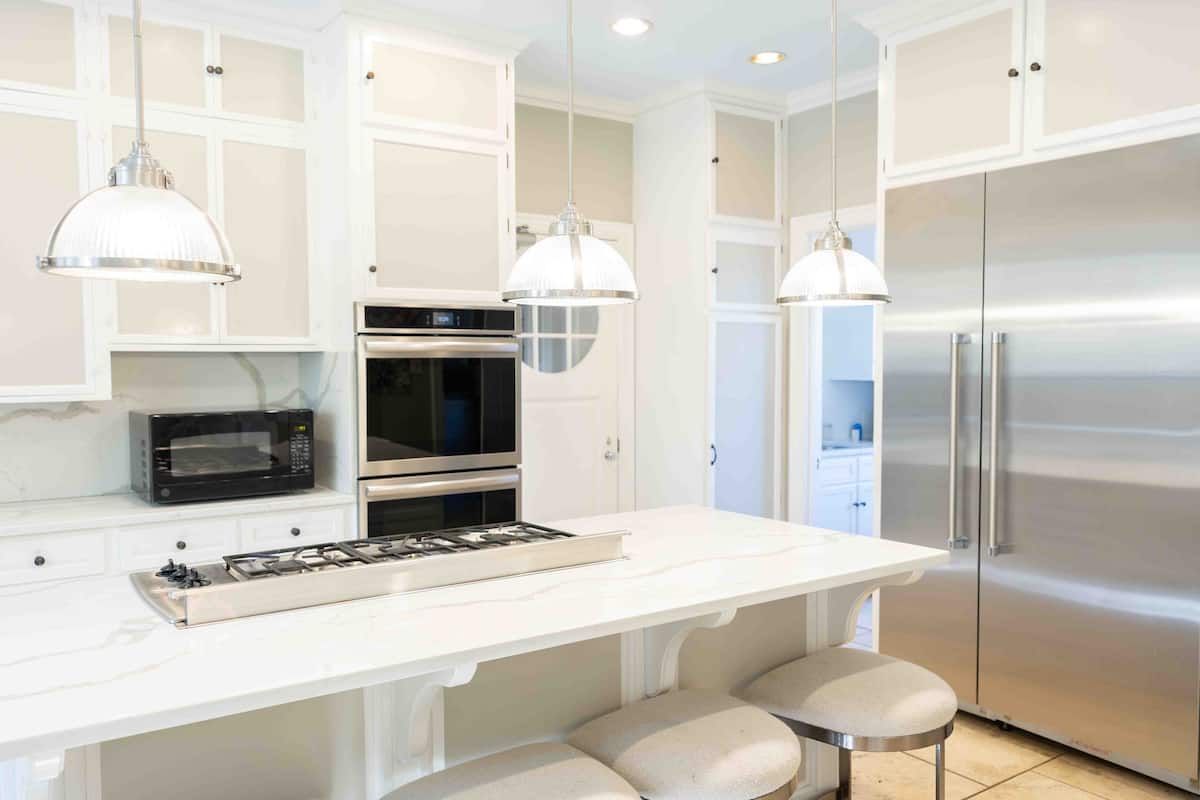 Bright white kitchen with marble island and gas cooktop