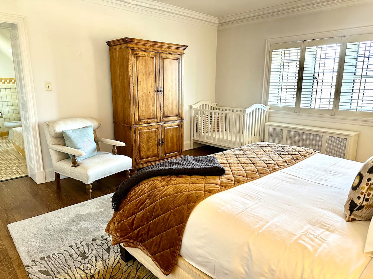Bedroom with wooden armoire and en-suite bathroom