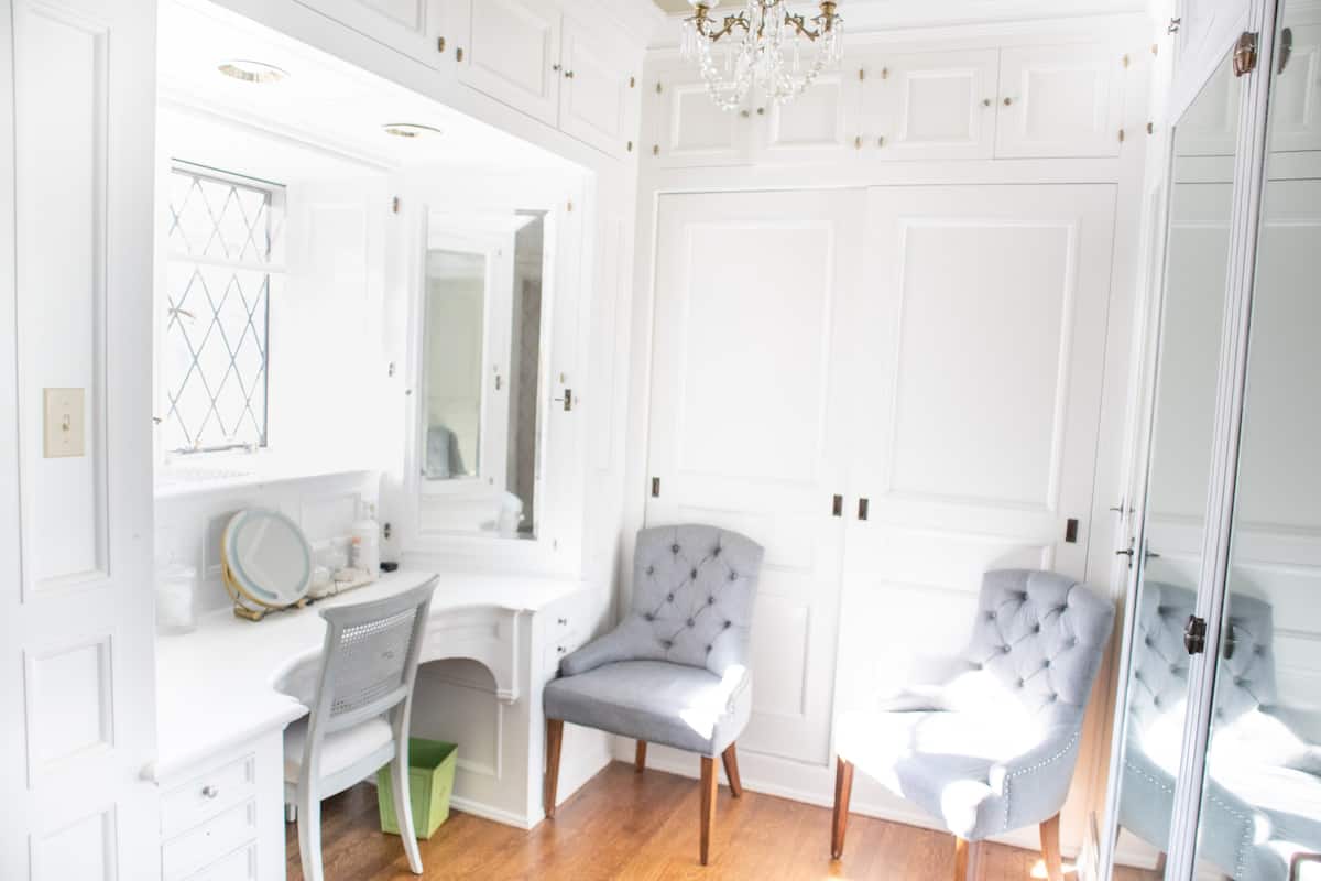 Dressing room with built-in vanity and tufted chairs