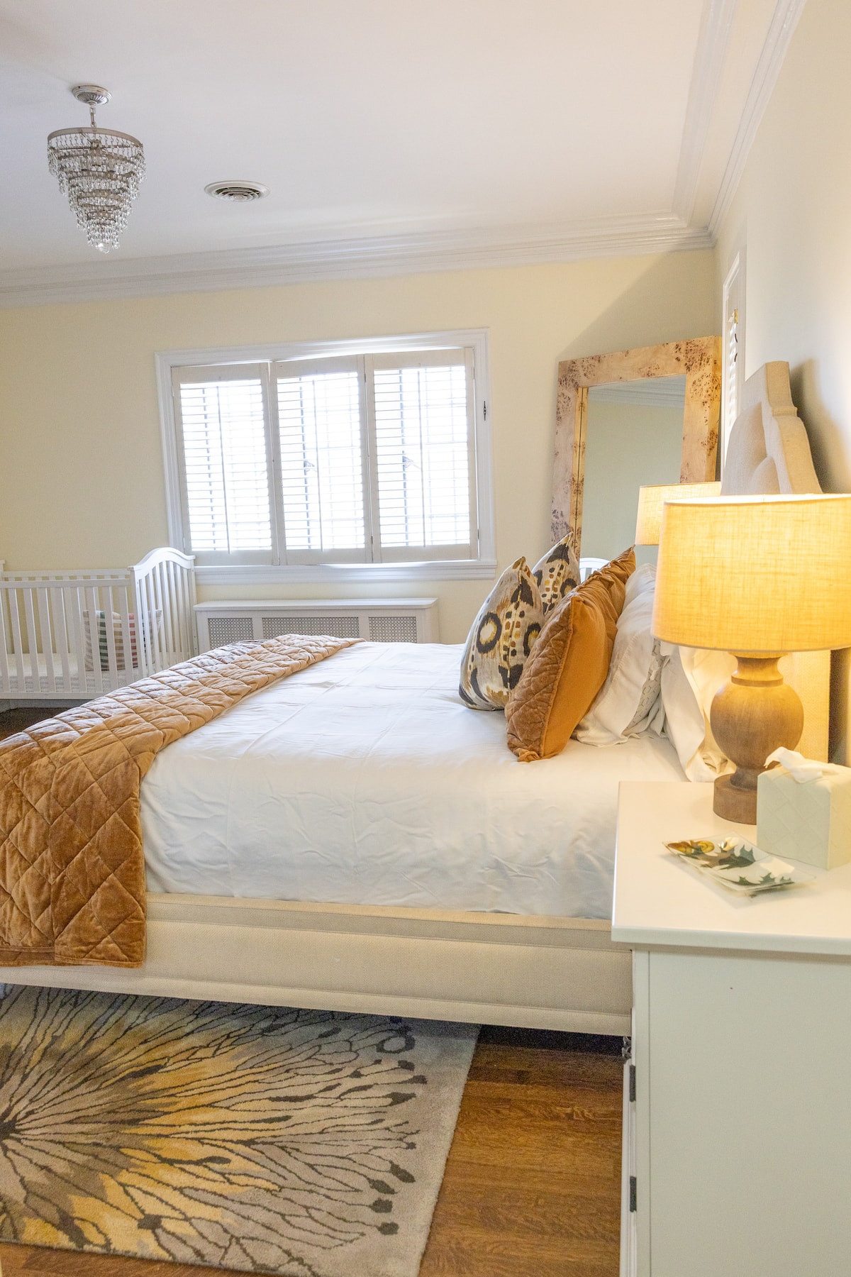 Bedroom with gold velvet bedding and crystal chandelier