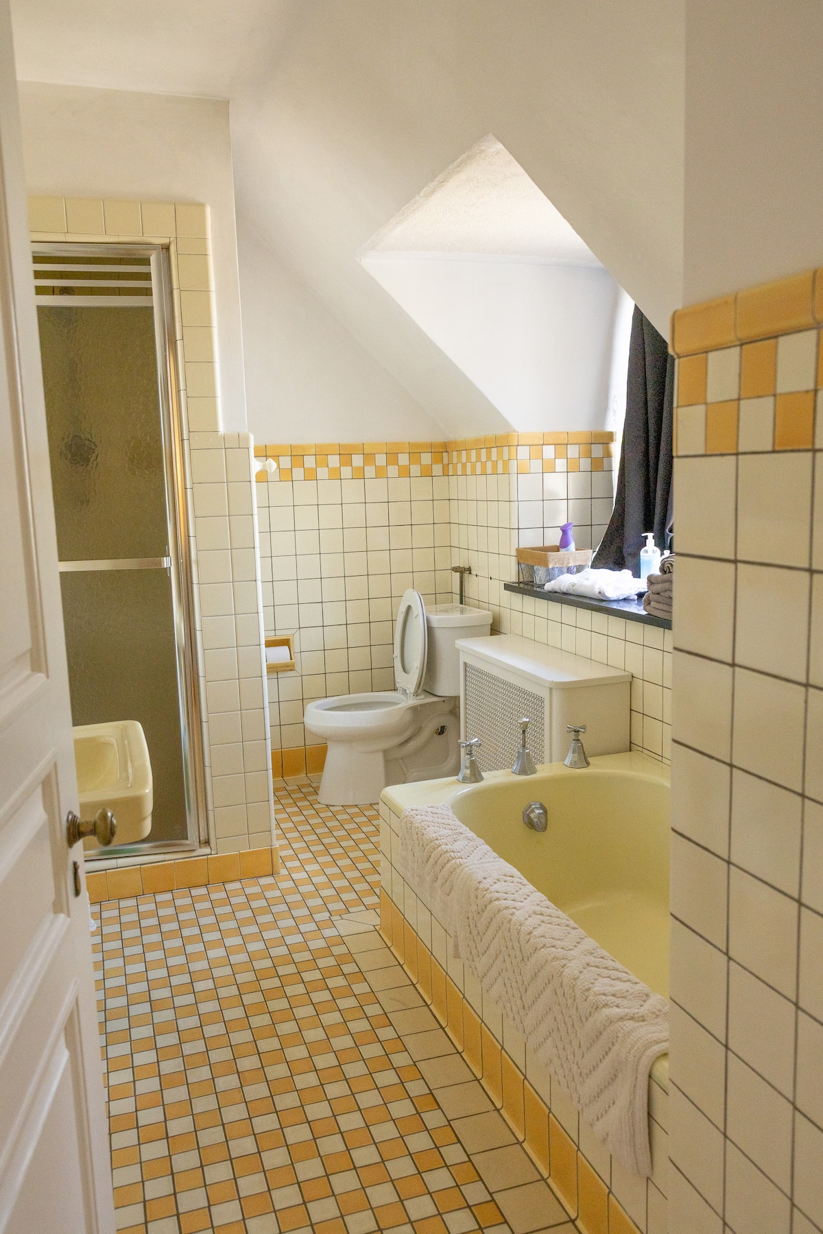 Small green-tiled bathroom with arched ceiling and vessel sink