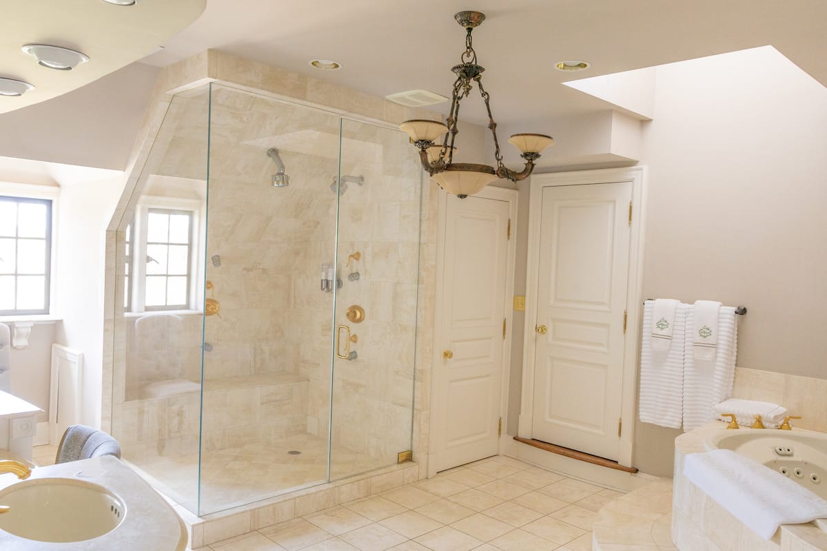 Luxurious marble bathroom with soaking tub and glass shower