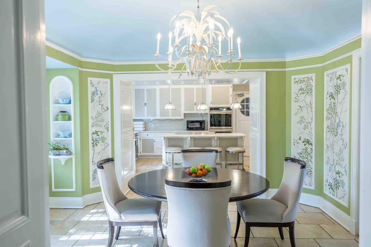 Elegant dining room with green walls and chinoiserie panels