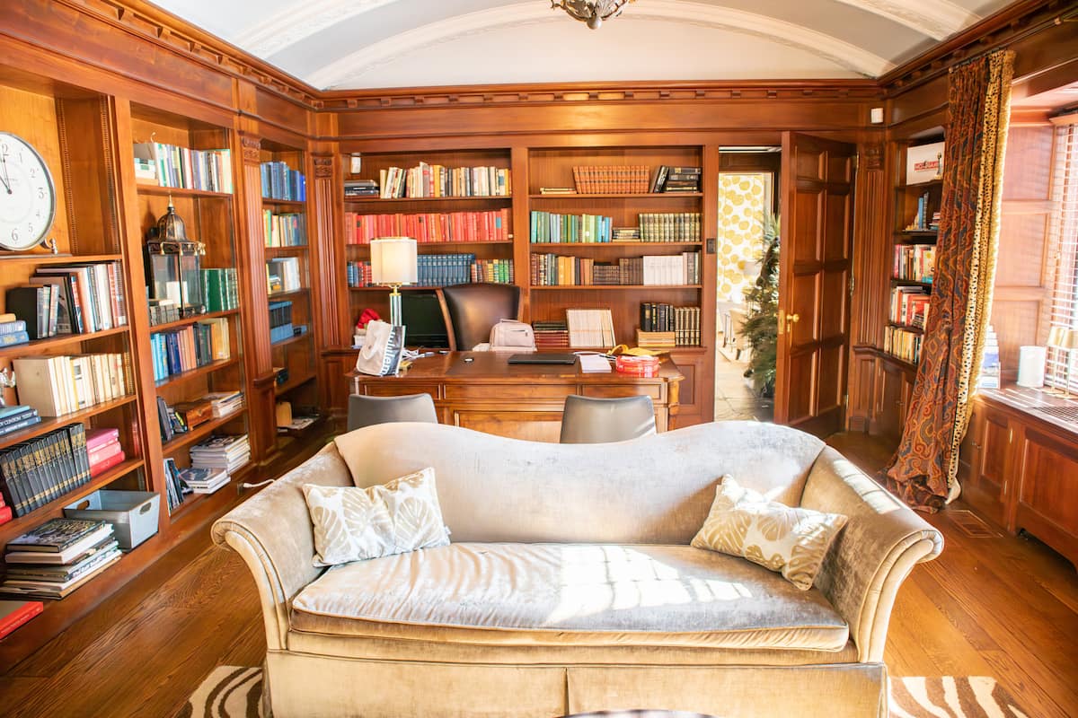 Wood-paneled library with leather sofa and desk
