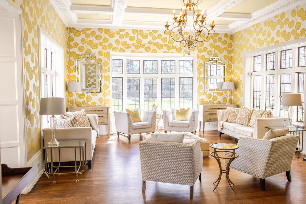 Bright sitting room with botanical wallpaper and chandelier